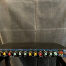 Černý rackový efekt procesor s modrými detaily na předním panelu. Na pravé straně je bílý nápis Lesta koza RV-3 a pod ním text REVERBERATION DEVICE.…