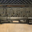 Otevřený černý kufr s vnitřní pěnovou výplní, který slouží jako pedalboard. Na povrchu je nápis UNIVERSAL EFFECTS PEDAL FLOOR BOARD WITH DC POWER SUP…