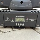 Černý svítící přístroj typu Moving Head s nápisy EUROLIGHT a behringer. Na panelu jsou vidět označení SLAVE MOVING HEAD MH710, kontrolky DMX, MASTER…