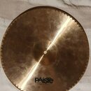 Kulatý mosazný činel s ozubeným okrajem. Na povrchu je vidět nápis PAiste a pod ním menší text MADE IN SWITZERLAND. Povrch je nerovnoměrně broušený s…