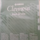 Fotografie zachycuje obálku uživatelské příručky k digitálnímu pianu. Na šedém pozadí je bílý nápis Clavinova a nad ním logo a značka YAMAHA. Pod náz…