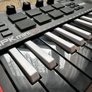 Černý MIDI kontrolér s klávesami a gumovými pady. Na přístroji je bílý nápis MPK miniplay a v pravém horním rohu logo AKAI PROFESSIONAL. Povrch je v…