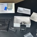 Sada bezdrátového mikrofonu v originálním balení. Obsahuje odesílač s nápisem SYNCO Receiver, přijímač s nápisem SYNCO Transmitter a větrný kryt z še…