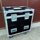 Černý transportní case s hliníkovými hranami a rohovými chrániči. Na přední straně jsou dva horní zámky a dvě spodní úchytné madla, v dolní části jso…