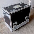 Černý transportní case s kovými hranami a rohovými chrániči. Na horní straně jsou čtyři zapadlé úchyty a jeden průhledný plastový prostor pro štítky.…
