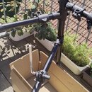Černý kovový stojan s teleskopickými rameny a nastavitelní výškou. Na spojovacích elementech jsou vidět šroubovací knoflíky pro fixaci polohy. Konstr…