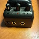 Černý kytarový efekt s třemi ovládacími knoflíky. Na horní části je viditelný nápis CYBERDRIVE a SOUNDTRACK, na přední straně jsou nápisy AOUT GAIN A…