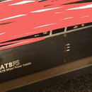 Černý rackový zdroj s nápisem ATBPS ATB Mixer Power Supply. Na pravé straně je logo a text Toft Audio Designs. V levé části se nachází červený vypína…