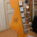 Zadní strana hlavy kytary z přírodního dřeva s chromovanými ladičkami. Na dřevě je černý nápis: Designed and Backed by Fender V/N ICS2008894 Crafted…