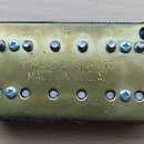 Kytarový snímač s mosazným krytem a černým kabelem. Na krytu je vyražen nápis DIMARZIO PICKUPS MADE IN U.S.A. a písmeno F. Na bílé nálepce je uveden…