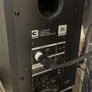Zadní strana černého studiového reproduktoru s nápisy 3 SERIES, LINEAR SPATIAL REFERENCE a logem JBL PROFESSIONAL. V horní části je kulatý odrazový o…
