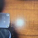 Detail kovového špecifikace na hředni nástroje s nápisy Ibanez, E830030 a MADE IN JAPAN. Kovový povrch vykazuje drobné škrábance a opotřebení. Vedle…