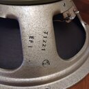Detail zadní strany reproduktoru s kovovým, stříbrným rámem a olivově zeleným magnetem. Na rámu jsou černé nápisy T1221 a EF1 oraz malé kulaté logo,…