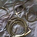 Čtyři černé instrumentní kabely různých délek položené na tmavé látce s motivem hvězd. Na jednom z konektorů nejdelšího kabelu je viditelný nápis Fen…