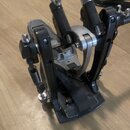 Černý bicí pedál s kovovými prvky v stříbrné barvě. Nástroj vykazuje známky používání a lehké znečištění povrchu. Na fotce nejsou žádné čitelné značk…