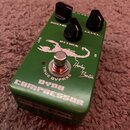 Zelený kytarový efekt s nápisy DYNA COMPRESSOR a Harley Benton. Na horní straně jsou tři černé ovládací knoflíky s popisky SUSTAIN, ATTACK a LEVEL. U…