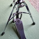 Chromovaný stojan s pedálem, který má na horní části nápis YAMAHA a doprovodné logo. Na spodní části pedálu je viditelný nápis PROFESSIONAL MODEL. Po…