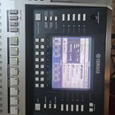 Detailní záběr na ovládací panel digitálního klavíru značky YAMAHA. Uprostřed je LCD displej zobrazující nastavení s nápisy jako NewSong, Cool8Beat a…