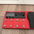 Červený kytarový procesor s nápisem VALETON GP-200R MULTI EFFECTS PROCESSOR. Zařízení má displej, několik ovládacích knoflíků a osm stoupakových spín…