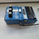 Modrý kytarový efekt s třemi černými ovládacími knoflíky. Na šasi jsou nápisy FX Delay 90, DELAY a MAX REPEAT. V pravé části je černý spínací pedál s…