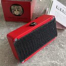 Červený kytarový efekt v kovovém šasi s černým suchým zipem na spodní straně. V pozadí je červená krabice s logem lva a nápisem electro-harmonix. Ved…