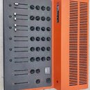 Oranžový míchací pult s černým ovládacím panelem. Na boku je uveden nápis STUDIO MIX B-30 a logo v červeném čtverečku. Panel obsahuje několik posuvní…