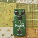 Zelený kytarový efekt pedál s nápisy DRIVE, LEVEL a TONE u ovládacích knoflíků. Uprostřed je bílý nápis TUBE MAN MK II OVERDRIVE s ikonou vakuumové t…