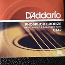 Balení kytarových strun značky D'Addario. Na obalu je uveden nápis PHOSPHOR BRONZE, WARM, BRIGHT, & BALANCED TONE a model EJ42. V horní části je uved…