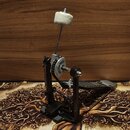 Černý basový pedál s kovovou konstrukcí a bílým plstěným beaterem. Na stříbrném nastavovacím kolečku je nápis POWER GLIDE. Pedál vykazuje mírné známk…