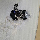 Modré sluchátka in-ear s opleteným stříbrným kabelem. Sluchátka jsou umístěna v černém přepravním pouzdře spolu s průhledným sáčkem obsahujícím náhra…
