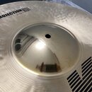 Detailní záběr na střed stříbrného činely s výrazným rýhováním a klepaným povrchem. Na pravé straně je černý nápis PROJECTION RIDE a pod ním menší te…