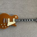 Hnědá elektrická kytara s tvarem singlecut a bílým plechtrzem. Na hlavě je viditelné logo „Epiphone“. Nástroj má dva humbuckery s bílými rámečky a čt…