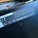 Detail štítku na zadní straně černého hudebního zařízení. Je zde viditelné logo ENSONIQ a text FCC týkající se shody s pravidly Part 15. Štítek obsah…