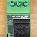 Zelený kytarový efekt s nápisy TUBE SCREAMER CLASSIC a TS10. Na horní části jsou tři modré otočné ovladače s popisky DRIVE, TONE a LEVEL. V dolní čás…