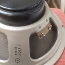 Fotografie zachicuje zadní stranu reproduktoru s černým magnetem a světle šedým kovovým rámem. Na rámu je černý nápis AM18 a pod ním kód Г1632, dopln…