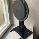 Černý kovový stojan s kulatou horní deskou. Na desce je v horní části vyražený nápis Gibraltar a ve spodní části nečitelný nápis. Povrch je matně čer…