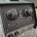 Černý rackový přístroj s nápisem UNIVERSAL AUDIO SOLO/610 Classic Vacuum Tube Mic Pre & DI Box. Přední panel obsahuje dva velké černé otočné ovladače…