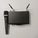 Černý bezdrátový mikrofon a doprovodný přijímač s dvěma anténami. Na těle mikrofonu je bílý nápis AKG a níže označení HT400. Přístroje jsou v dobrém…