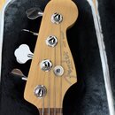 Hlava basové kytary z přírodního dřeva s nápisy Fender, JAZZ BASS® a MADE IN U.S.A. Nástroj má čtyři chromované ladičky s kovovými knoflíky. Je polož…