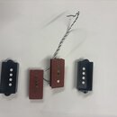 Čtyři kytarové snímače typu single-coil. Dva jsou v černých plastových rámečcích a dva jsou bez rámečků s červeným povrchem. Jeden ze snímačů má přip…