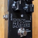 Černý kytarový efekt s nápisy tc electronic a DARK MATTER DISTORTION. Na horní straně jsou čtyři černé otočné knoflíky a jeden kovový spínací pedál s…