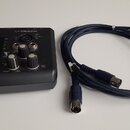 Černý zvukový interface s nápisy M-AUDIO a M-TRACK. Zařízení obsahuje několik regulačních knoflíků, přepínačů a vstupních konektorů. Vedle zařízení j…