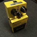 Žlutý kytarový efekt s nápisy SUPER Over Drive a SD-1w. Na horní straně jsou tři ovládací knoflíky, červená kontrolka CHECK a nápisy MADE IN JAPAN or…