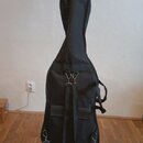 Černý softcase (obal) na hudební nástroj s tvarem připomínajícím kytaru nebo basu. Obal je vybaven dvěma nastavтельными ramenními popruhy s kovovými…