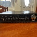 Černý basový zesilovač v rackovém provedení s kovovými úchyty po stranách. Na předním panelu je nápis PROFESSIONAL BASS AMPLIFIER a logo WorkingPro s…