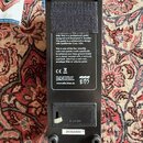 Spodní strana černého efektového pedálu s textem na štítku: EBS Stanley Clarke Wah Pedal S/N 340782. Na spodní části je umístěno logo EBS a webová ad…