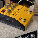 Žlutý kytarový efekt BOSS DD-200 HYBRID DRIVE. Na horní straně jsou ovládací knoflíky, červený digitální displej s číslem 7-9 a přepínače. Na boku js…