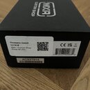Černý papírový obal s bílým logem MXR a nápisem CUSTOM SHOP. Na boku jsou dvě bílé nálepky; první obsahuje text Thomann GmbH, 117418, MXR - Custom Sh…