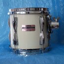 Bílá buben (tom) s chromovaným kováním. Na korpusu je nalepený štítek s nápisy YAMAHA, MODEL TND80 a SER. NO. 41579, dole je uveden text MADE IN JAPA…