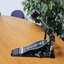 Černý basový pedál s kovovými komponenty. Na stupni je bílý nápis "7000" a pod ním text "Drummation Ltd. London". Pedál vykazuje mírné známky opotřeb…